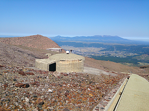 避難小屋の向こうに廃墟と化したロープウェイ火口東駅